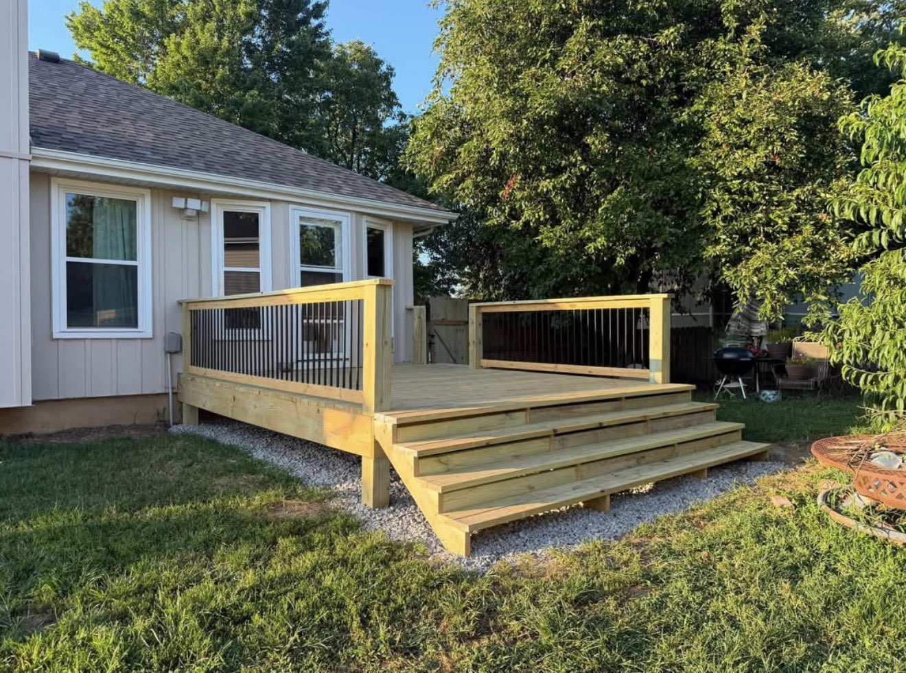 Newly built wooden deck with railings on the back of a house
